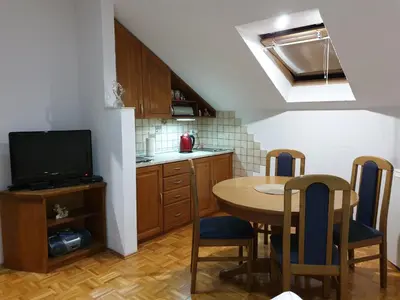 a kitchen with a table and a tv and a table and chairs at Apartmani Ćurković in Kupres