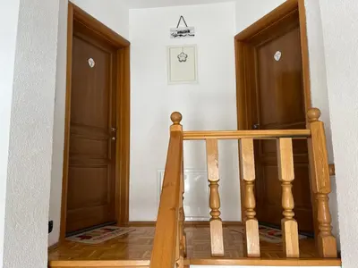 a hallway with two wooden doors and a staircase at Apartmani Ćurković in Kupres