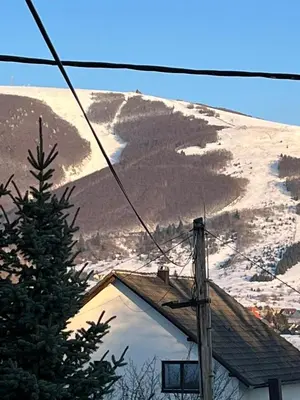a view of a snow covered mountain from a house at Apartmani Ćurković in Kupres