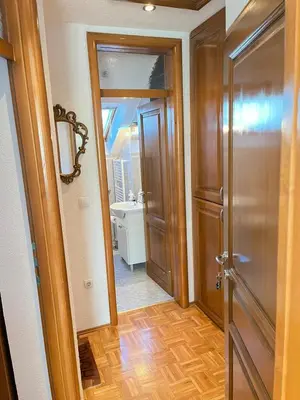 a hallway with a door and a bathroom with a sink at Apartmani Ćurković in Kupres