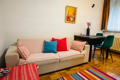 a living room with a couch with colorful pillows on it at Apartman Olivia in Banja Luka