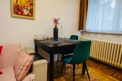 a room with a table with two chairs and a couch at Apartman Olivia in Banja Luka