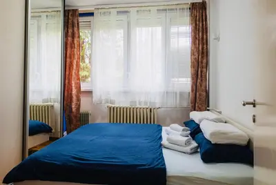 a bedroom with a blue bed and a window at Apartman Olivia in Banja Luka