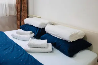 three pillows and towels are sitting on a bed at Apartman Olivia in Banja Luka