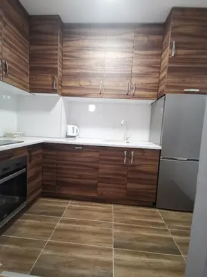 a kitchen with wooden cabinets and a stainless steel refrigerator at CITY in Banja Luka