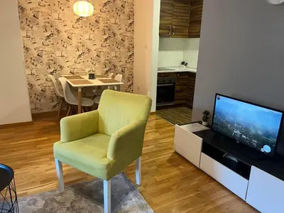 a living room with a green chair and a television at CITY in Banja Luka