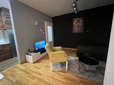a living room with a yellow chair and a couch at CITY in Banja Luka