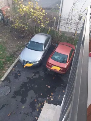 two cars parked in a parking lot next to a building at Apartman Mango Banja Luka center hospital Free parking in Banja Luka