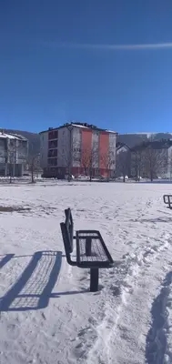 a bench sitting in the snow in a field at Apartman Luka in Kupres
