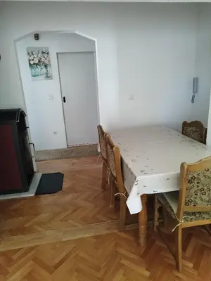 a dining room with a table and chairs and a tv at Apartman Luka in Kupres