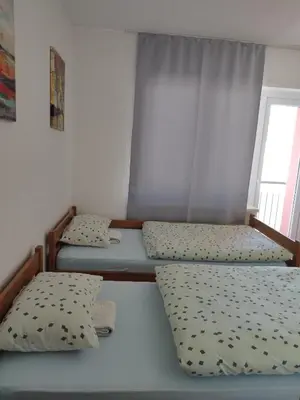 two beds in a room with a window at Apartman Luka in Kupres