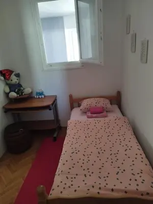a small bedroom with a bed and a window at Apartman Luka in Kupres
