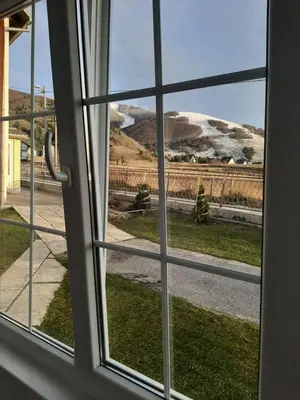 a window with a view of a snow covered mountain at -Moon- in Kupres
