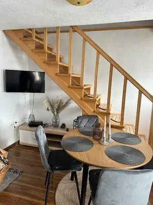 a dining room with a table with chairs and a staircase at -Moon- in Kupres