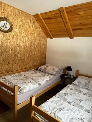 two beds in a room with wooden ceilings at -Moon- in Kupres