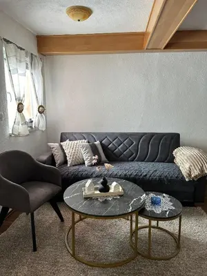 a living room with a black couch and a table at -Moon- in Kupres