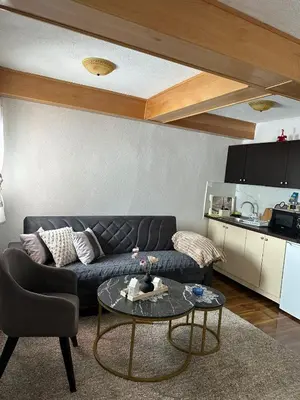 a living room with a black couch and a table at -Moon- in Kupres