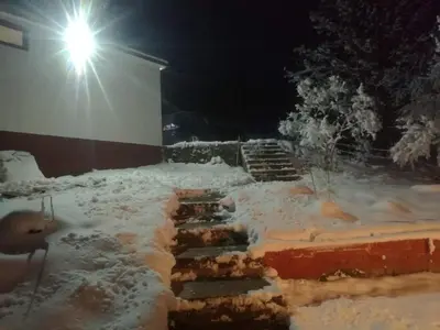 a snow covered steps in front of a building with a light at Vlasic holiday home in Vlasic