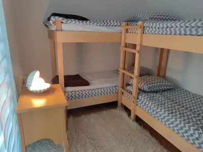 a bunk bed room with two bunk beds and a table at Vlasic holiday home in Vlasic