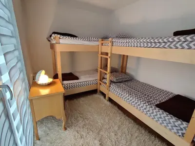 two bunk beds in a room with a desk at Vlasic holiday home in Vlasic