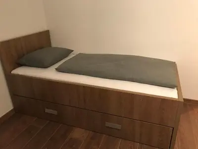 a bed with a wooden bed frame and a drawer at Sarah in Kupres