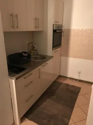 a small kitchen with white cabinets and a sink at Sarah in Kupres