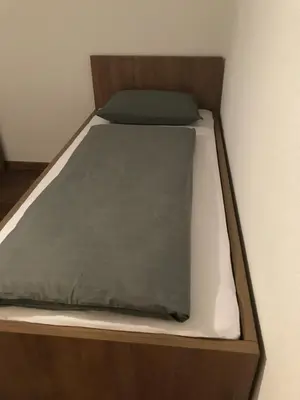a wooden bed with a green blanket on it at Sarah in Kupres
