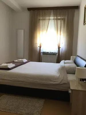 a bedroom with a large bed and a window at Bingo Apartments in Banja Luka