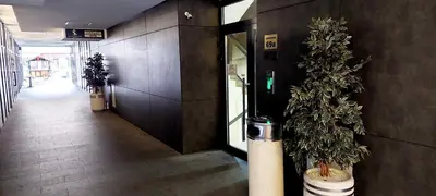an empty hallway with a tree in a building at Extra Apartman-City Center with Parking in Banja Luka