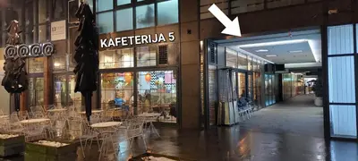 a store with tables and chairs inside of a building at Extra Apartman-City Center with Parking in Banja Luka