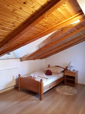 a bed in a room with a wooden ceiling at Apartman Ivana in Jajce