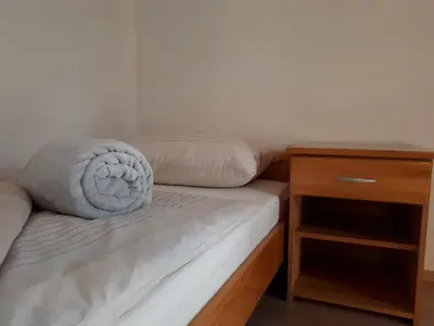 a bed with a pillow on it next to a nightstand at Apartman Ivana in Jajce