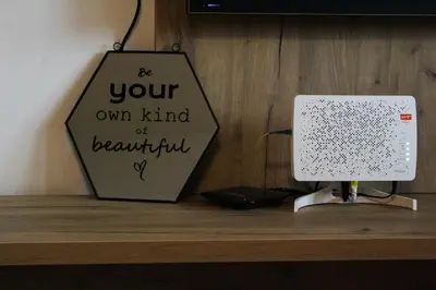 a sign on top of a wooden shelf with a router at Bright, modern & cozy apartment in Tuzla