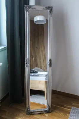 a mirror sitting on the floor in a room with a bed at Bright, modern & cozy apartment in Tuzla