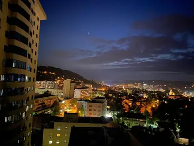 a view of a city at night at Bright, modern & cozy apartment in Tuzla