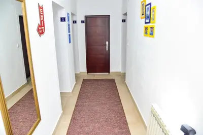 a hallway with a brown door and a mirror at Apartmani Koko in Banja Luka
