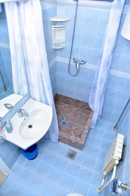 a blue bathroom with a sink and a shower at Apartmani Koko in Banja Luka