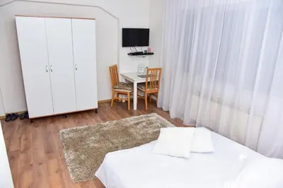a bedroom with a bed and a table with chairs at Apartmani Koko in Banja Luka