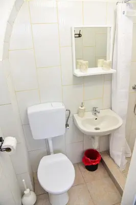 a white bathroom with a toilet and a sink at Apartmani Koko in Banja Luka