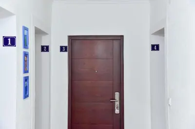 a wooden door in a hallway with numbers on the walls at Apartmani Koko in Banja Luka