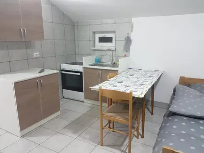 a small kitchen with a table and a sink at DASS apartmani in Banja Luka