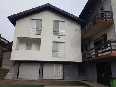a white house with white garage doors at DASS apartmani in Banja Luka