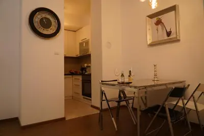 a dining room with a table and a clock on the wall at Jackey apartment in Banja Luka