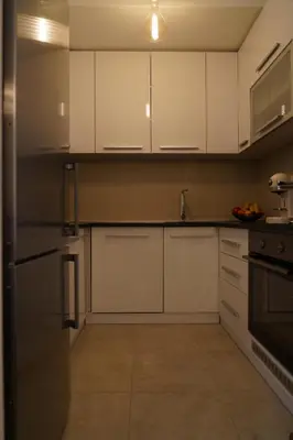 a kitchen with white cabinets and a stainless steel refrigerator at Jackey apartment in Banja Luka