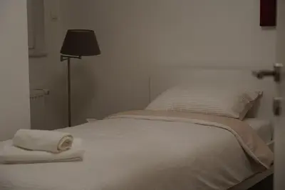a white bed with a white blanket and a lamp at Jackey apartment in Banja Luka