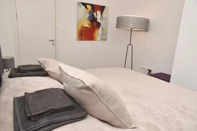 a bedroom with a bed with pillows and a lamp at Jackey apartment in Banja Luka