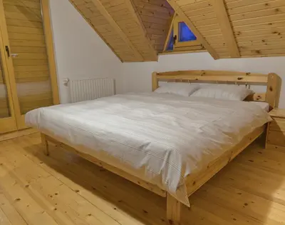 a bedroom with a large bed with a wooden frame at Kiwi Chalet in Kupres