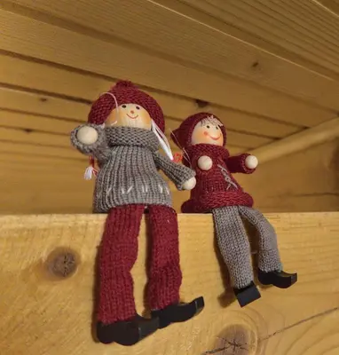 two dolls sitting on top of a wooden shelf at Kiwi Chalet in Kupres