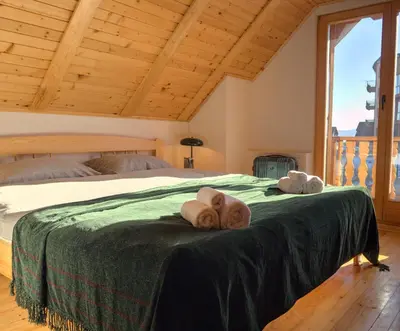 a bedroom with a bed with two towels on it at Kiwi Chalet in Kupres