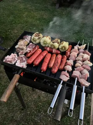 a grill with different types of meat and vegetables at Vikendica Eden in Vlasic